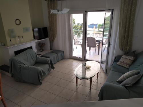 伊拉克里薩的住宿－Amalia Bay，带沙发和桌子的客厅以及天井。
