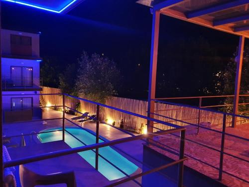 a swimming pool with lights on a balcony at night at Hotel Palladium Sithonia in Kalamitsi