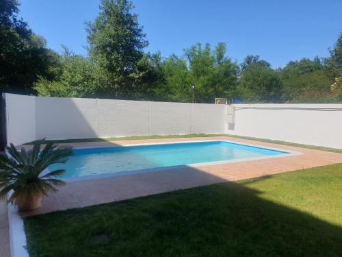 a swimming pool in a yard next to a fence at Hotel Millan in Negreira