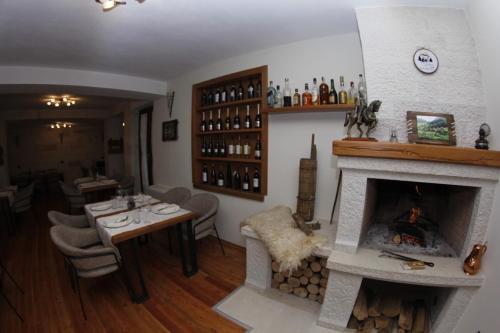 a living room with a fireplace and a dining room with a table at JOEN Village in Librazhd