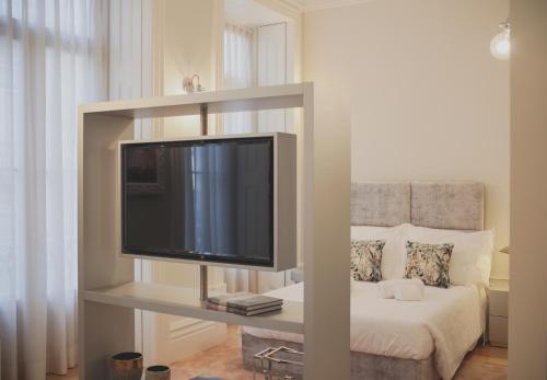 a flat screen tv on a shelf in a bedroom at viterbo'8 - The Artists House in Porto