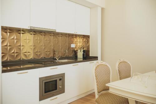 a kitchen with a sink and a microwave at viterbo'8 - The Artists House in Porto