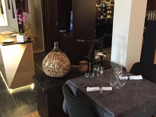 a table with two wine glasses and a vase at Hôtel L'Auberge Alsacienne in Eguisheim