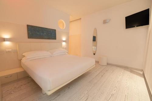 a bedroom with a white bed and a flat screen tv at Life Hotel Seaview & Spa in Porto Recanati