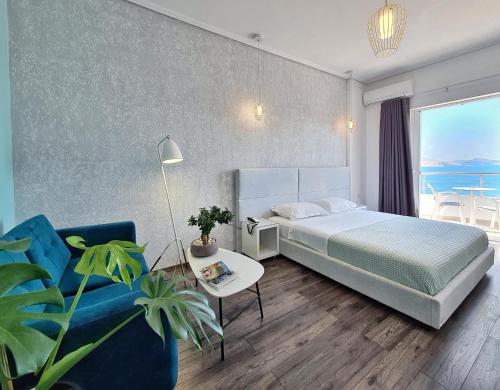 a hotel room with a bed and a blue couch at Hotel JoAn in Sarand&euml;