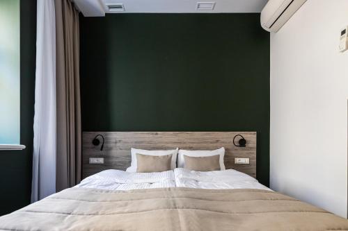 a bedroom with a large bed with a green wall at Oysters & Bubbles Gastro Hotel. Rynok square in Lviv