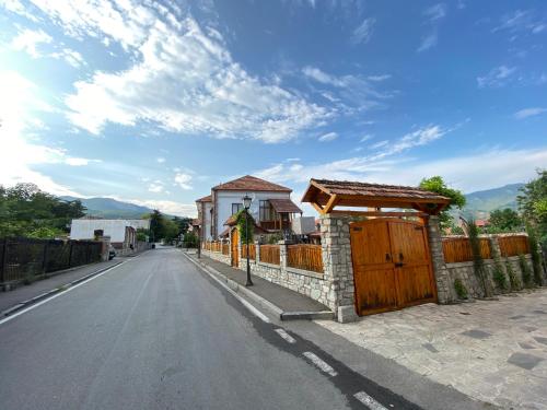 an empty street with a fence and a house at Hotel Aragvi in Mtskheta