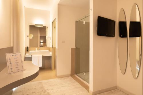 a bathroom with a sink and a tv on a wall at Life Hotel Seaview & Spa in Porto Recanati