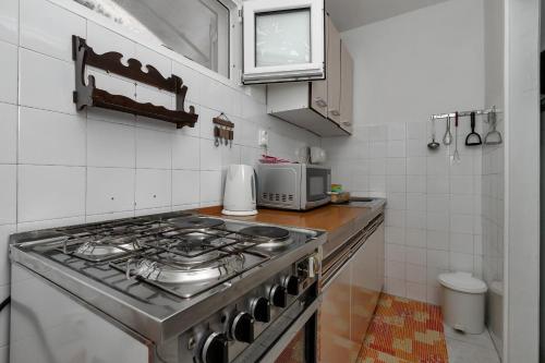 a kitchen with a stove and a microwave at Vila Milena in Krvavica