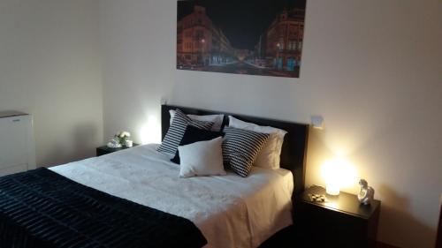 a bedroom with a large bed with two lamps at Turismo Homes Solar Do Areal in Braga