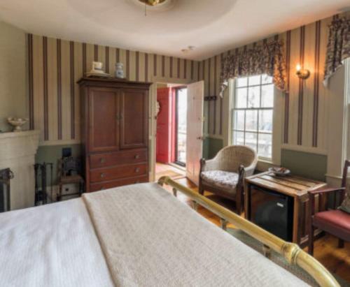 sypialnia z łóżkiem, krzesłem i stołem w obiekcie Snug Cottage w mieście Provincetown