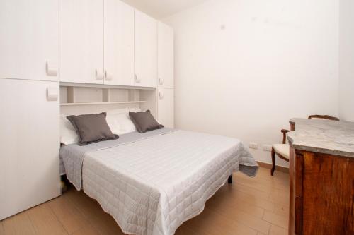 - une petite chambre blanche avec un lit et des placards blancs dans l'établissement Casa Tramonto by Wonderful Italy, à Cefalù