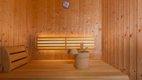a sauna with a bench and a clock on the wall at Alpine Appartement Top 3 by AA Holiday Homes in Tauplitz