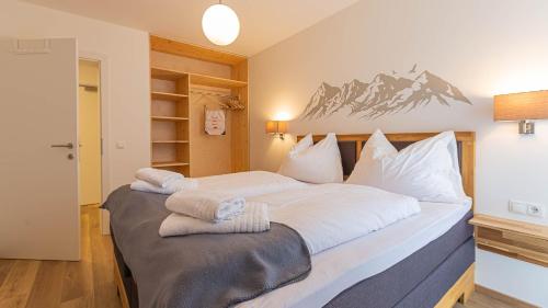 a bedroom with a large bed with towels on it at Alpine Appartement Top 3 by AA Holiday Homes in Tauplitz