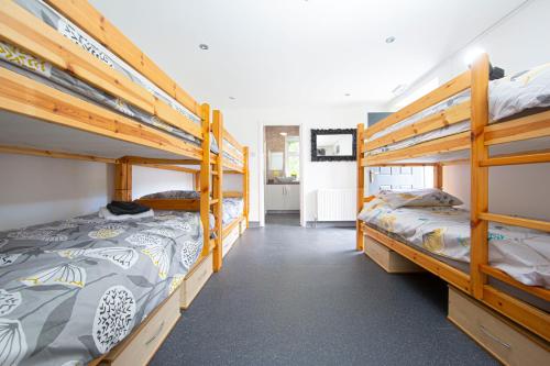 a room with two bunk beds and a hallway at The Glantaff Inn Bunkhouse in Treharris