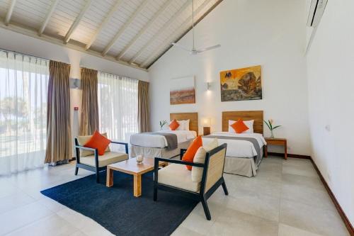 Cette chambre d'hôtel comprend deux lits, une table et des chaises. dans l'établissement Sangria Sun, à Wadduwa