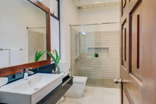 a bathroom with a sink and a toilet and a shower at Sangria Sun in Wadduwa