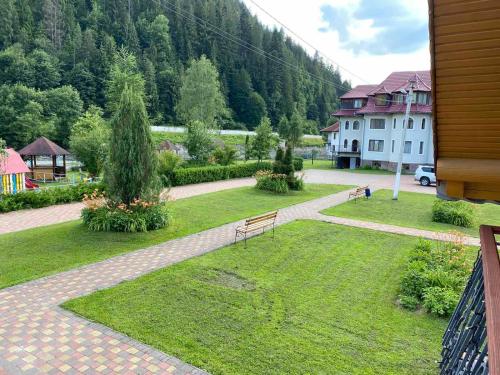a view of a park with a bench in the grass at Садиба "Джерело" in Yaremche