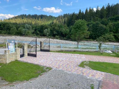a walkway with a gate next to a body of water at Садиба "Джерело" in Yaremche
