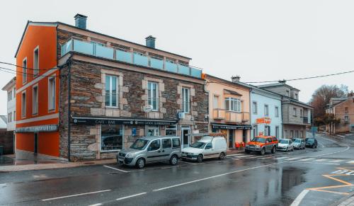 una calle de la ciudad con coches estacionados frente a los edificios en Pensión A Marronda, en Baleira