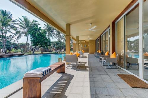 an outdoor patio with a pool and tables and chairs at Sangria Sun in Wadduwa