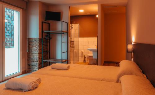 Un dormitorio con dos camas y un baño. en Pensión A Marronda, en Baleira