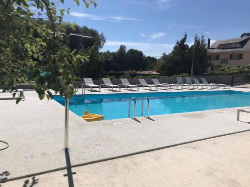 a swimming pool with lounge chairs and a swimming pool at Pensión CHE in O Pedrouzo