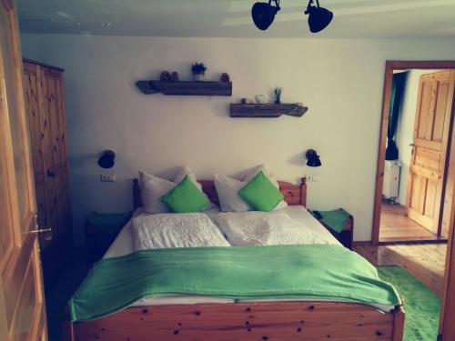 a bedroom with a bed with green sheets at Baumgartnerhof Arriach - Urlaub am Bauernhof in Arriach