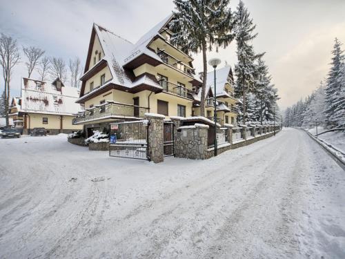 uma estrada coberta de neve em frente a uma casa em VisitZakopane - Olymp Apartament em Zakopane