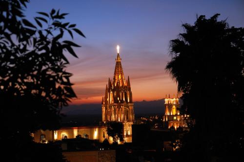 a church with a lit up tower at night at Casa Misha in San Miguel de Allende