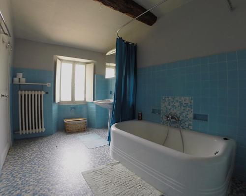 La salle de bains bleue est pourvue d'une baignoire et d'un lavabo. dans l'établissement Charmant appartement dans maison de village, à Magagnosc