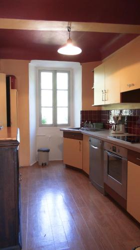 Il comprend une cuisine dotée de parquet et d'une grande fenêtre. dans l'établissement Charmant appartement dans maison de village, à Magagnosc