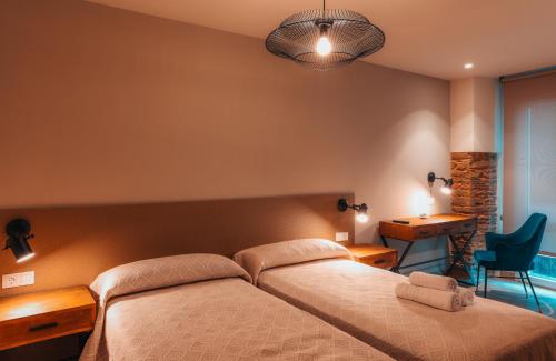 Un dormitorio con una cama, un escritorio y una silla. en Pensión A Marronda, en Baleira