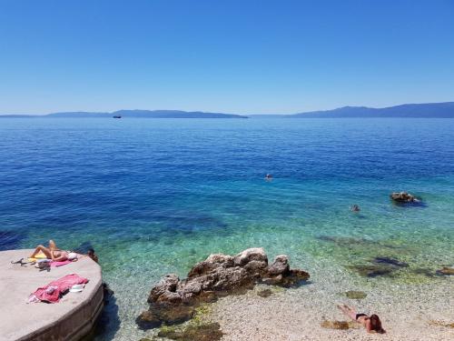 a group of people laying on the beach in the water at Volcano Rijeka in Rijeka