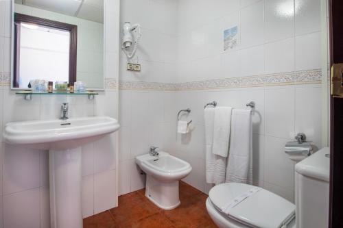 a white bathroom with a sink and a toilet at Hotel y Bungalows Balcón de Competa in Cómpeta