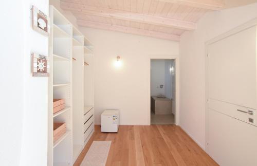 una camera con pareti bianche, pavimenti in legno e un corridoio di Tatta & Nanna Rooms a Oliena