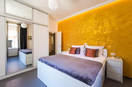 1 dormitorio con 1 cama grande y pared amarilla en Tony's Place, en Dubrovnik