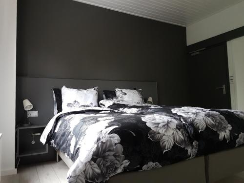 a bedroom with a bed with a black and white comforter at ANNO 1919 in Swalmen
