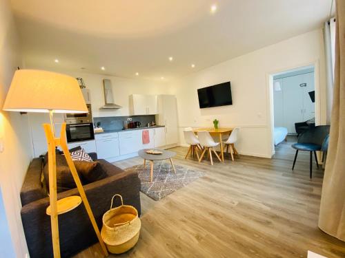a living room with a couch and a table at Hyper-centre Lille - Appartement John 65 m2 - Parking in Lille