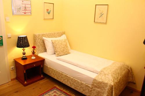 a bedroom with a bed and a table with a lamp at Seehotel Grüner Baum in Hallstatt