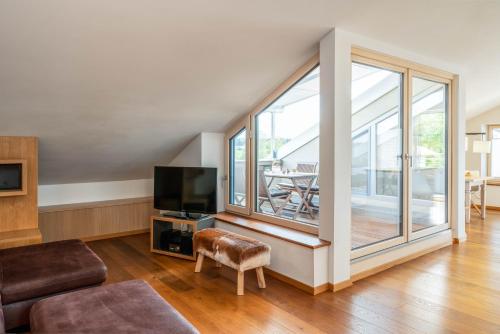 a living room with a large window and a tv at Lebensart am See in Bad Endorf