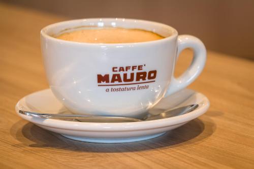 a cup of coffee on a plate on a table at Holiday Inn Express - Bodmin - Victoria Junction by IHG in Bodmin
