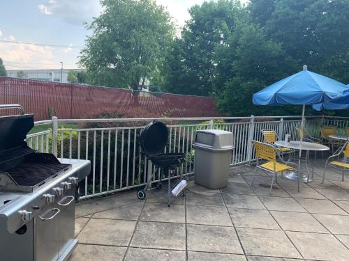 a patio with a grill and a table and an umbrella at Baymont by Wyndham Chambersburg in Chambersburg