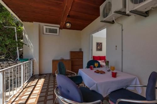 a room with a table and chairs on a balcony at Vila Milena in Krvavica