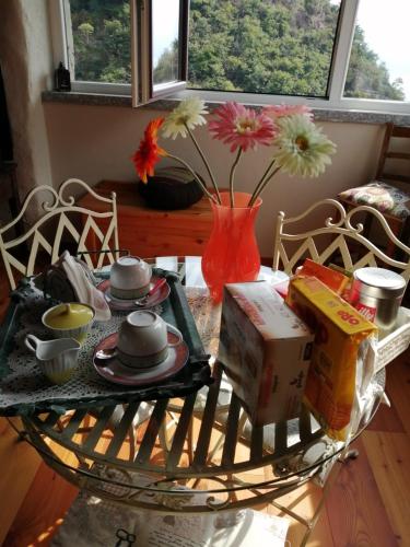 a coffee table with a vase with flowers in it at La casa della Cindy in Dervio