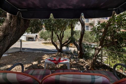 a table and chairs under a tree in a yard at Vila Milena in Krvavica