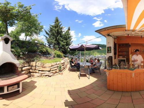 a patio with a grill and people sitting at a table at Hotel Villa Tummelchen in Cochem