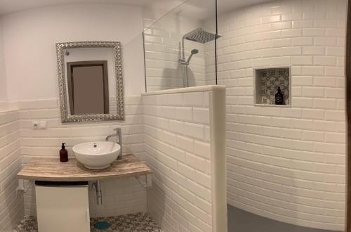 W białej łazience znajduje się umywalka i lustro. w obiekcie Sunset Caleta w Kadyksie