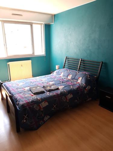 Bett in einem Schlafzimmer mit blauer Wand in der Unterkunft l'Horizon - F2 - 1er étage in Épinal