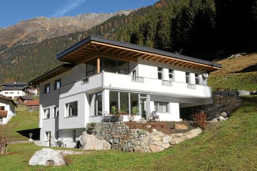 ein großes weißes Haus auf einem Hügel in der Unterkunft Ferienwohnung Hildegard Eiter in Sankt Leonhard im Pitztal